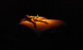 Goldfinger sculpture of a naked women in g-string spinning slowly on a circular bed